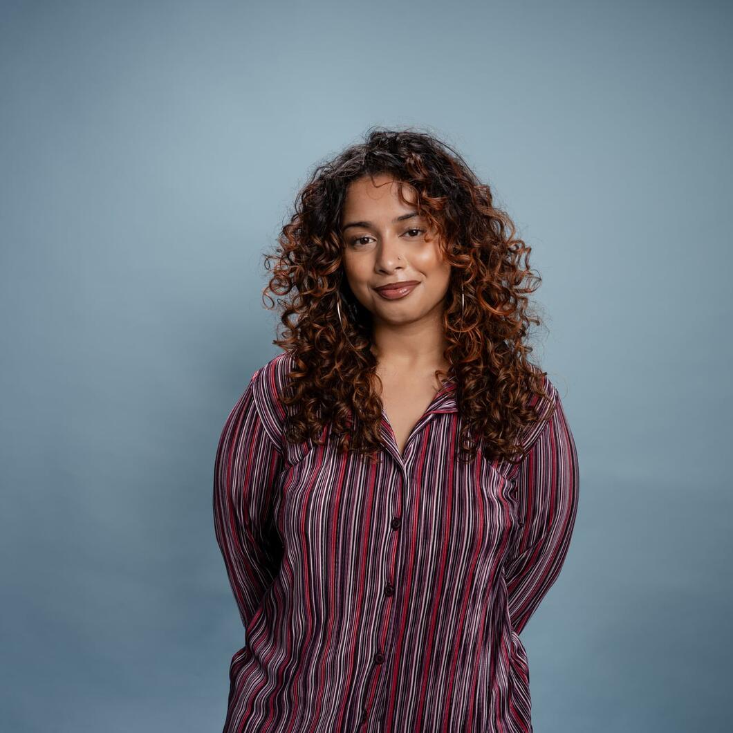 Tanisha kijkt glimlachend de camera in