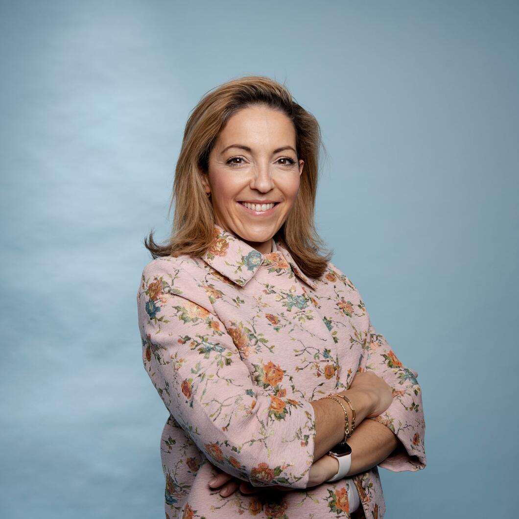 Nora kijkt lachend de camera in