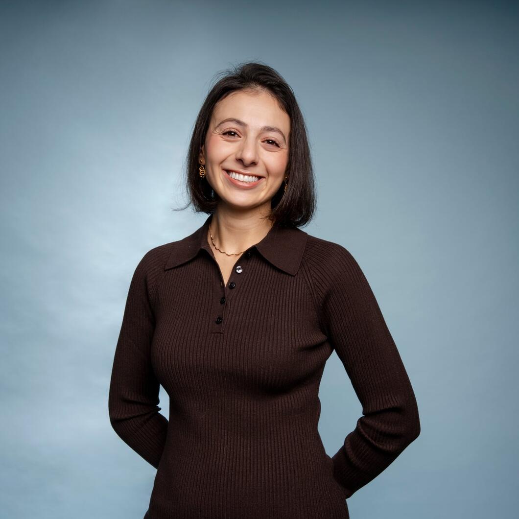Pelin kijkt lachend in de camera met haar handen op haar rug