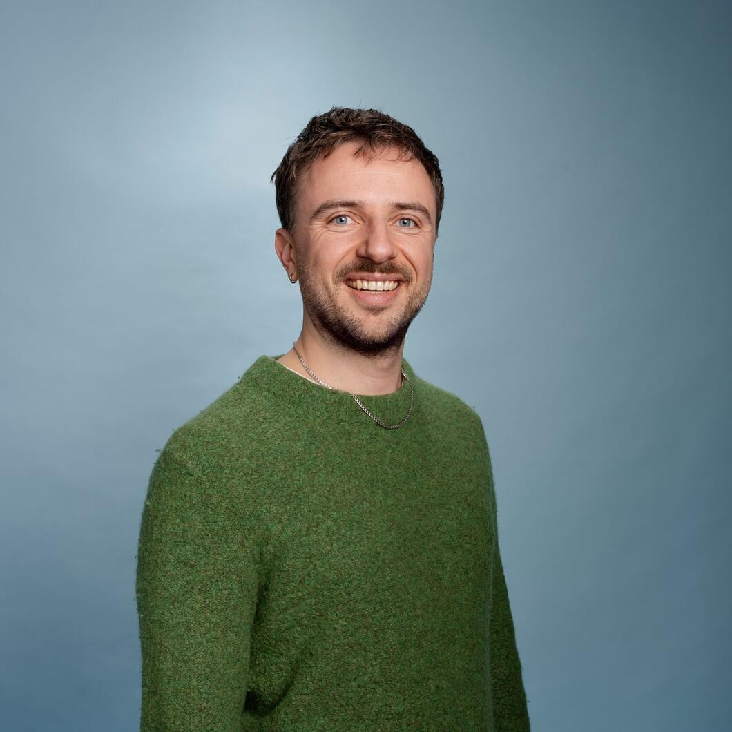 Thomas kijkt lachend de camera in