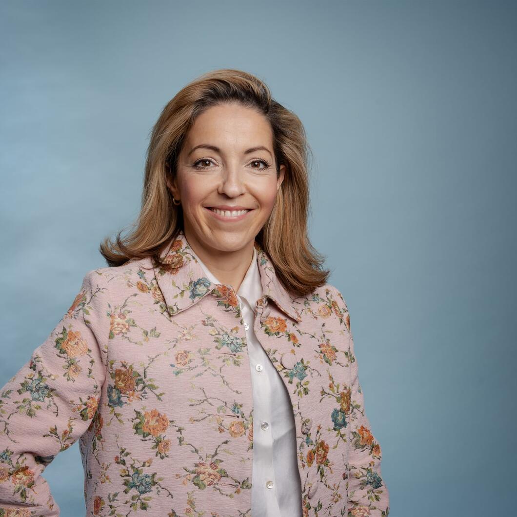 Nora kijkt lachende de camera in