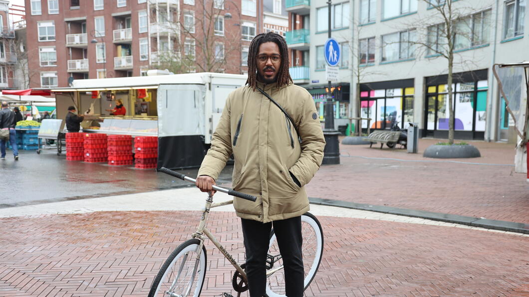Levien Wierenga met fiets op de Dappermarkt