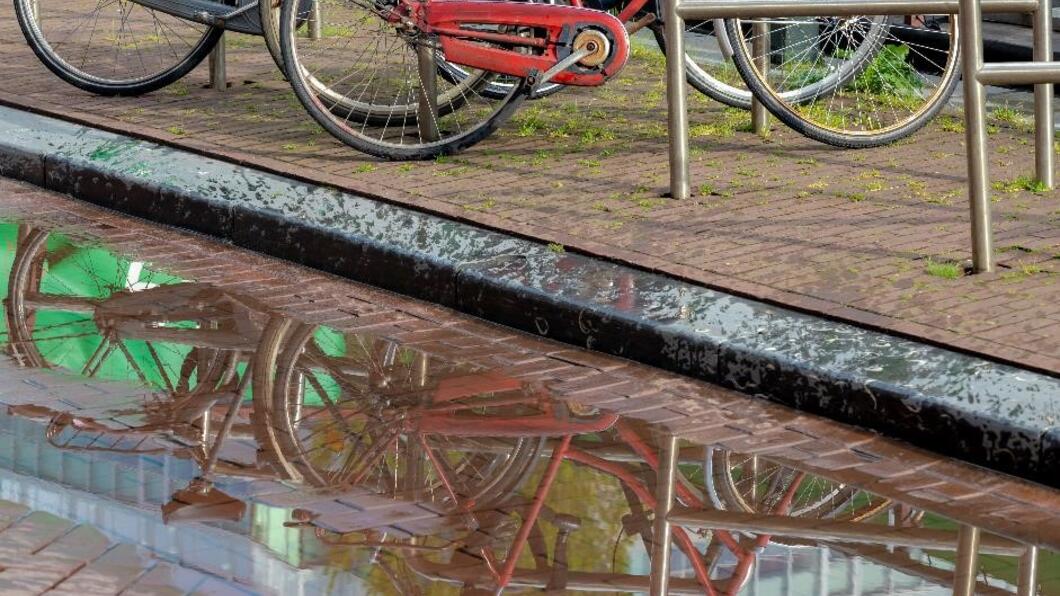 een plas naast een fietsenrek