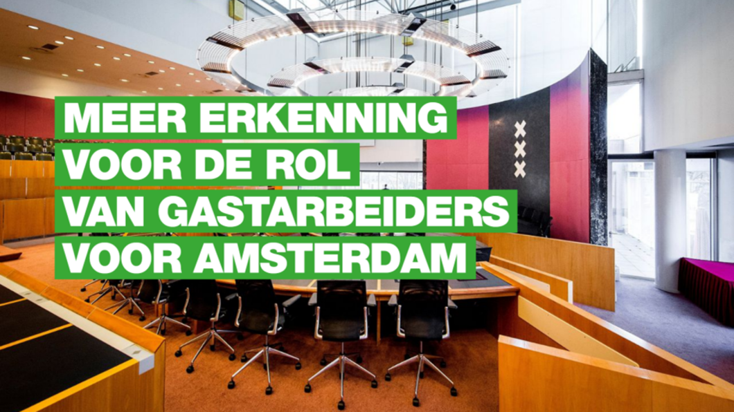 een lege gemeenteraadszaal met de tekst 'meer erkenning voor de rol van gastarbeiders voor Amsterdam'