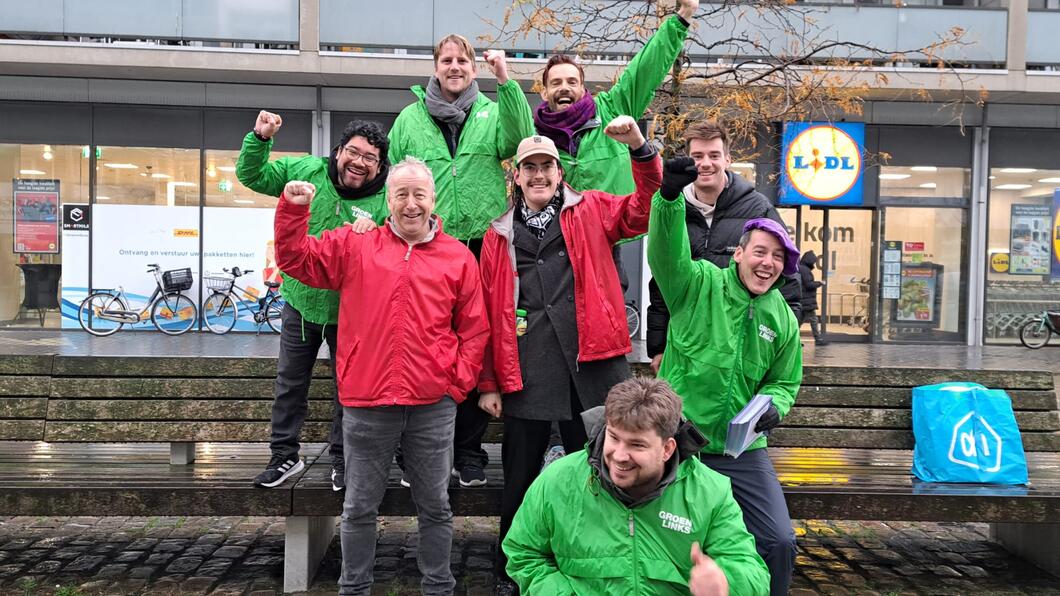 een groep mensen in rode en groene jasjes