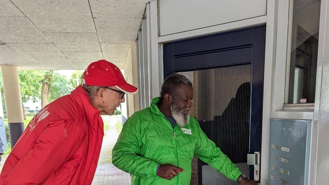 iemand in een rood en groen jasje bellen aan