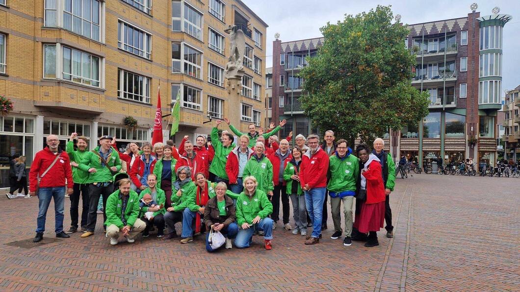 een groep mensen in rode en groene jasjes