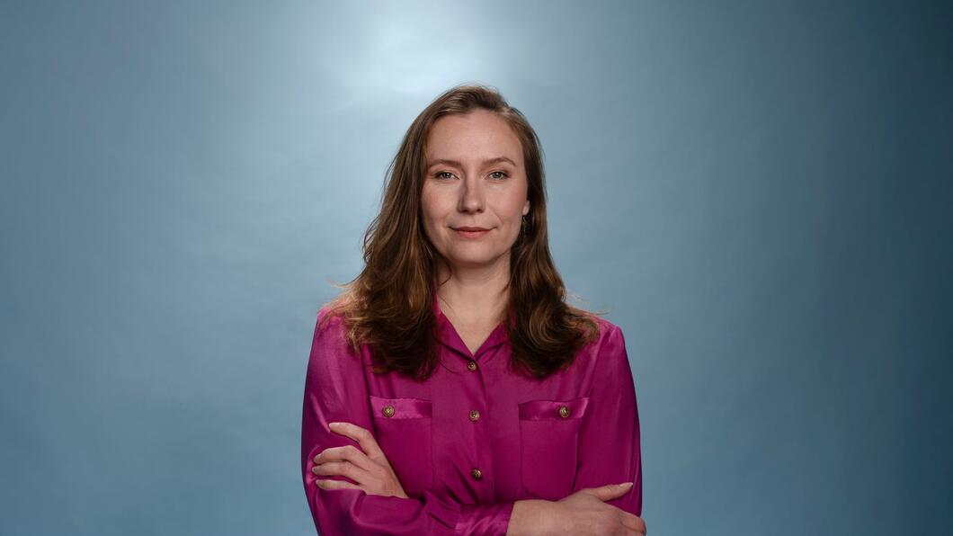 Zita Pels staat in een roze blouse met haar armen over elkaar