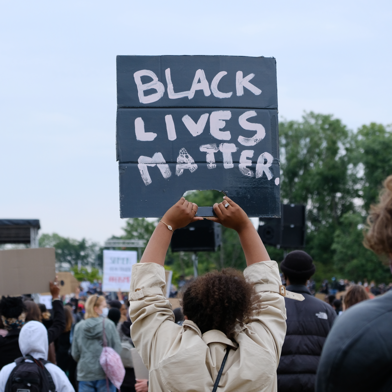 Persoon met een demonstratiebord met de tekst "Black Lives Matter"