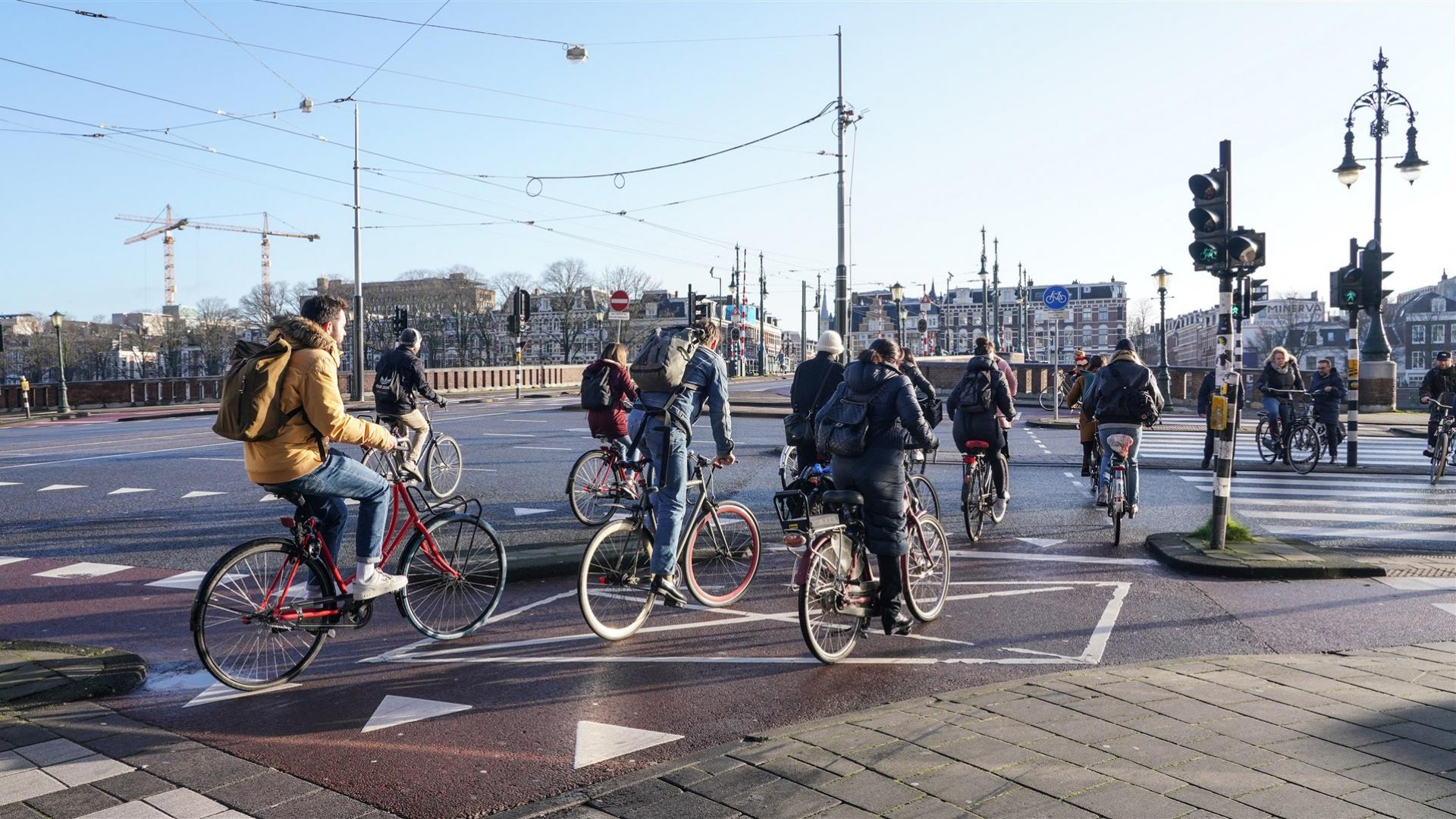 Fietsers op brug met tegenlicht van de zon