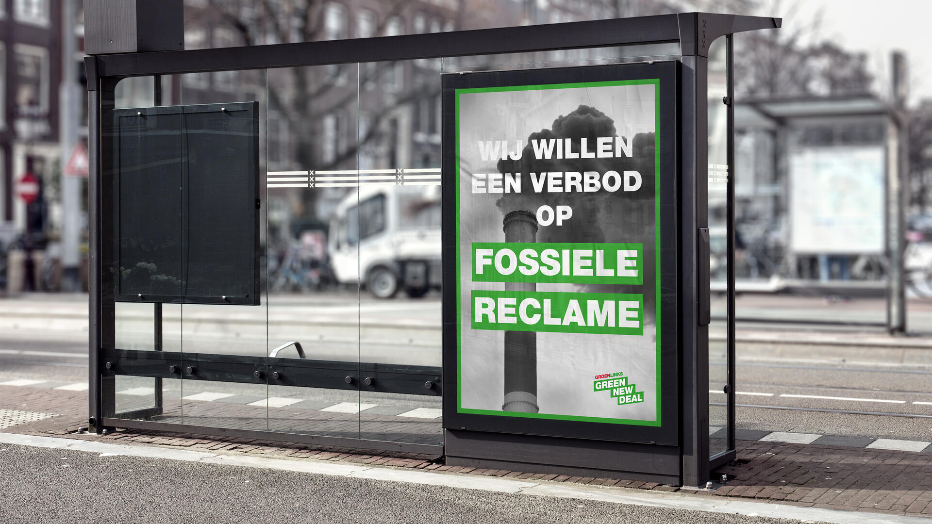 Een foto van een bushokje met een poster van een vieze schoorsteen, met daarom de tekst: "Wij willen een verbod op fossiele reclame"