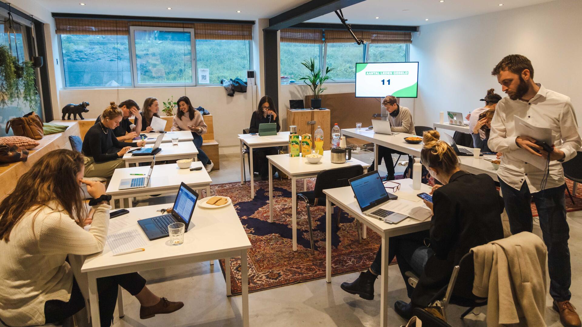 Zaal met vrijwilligers van GroenLinks die aan het bellen zijn