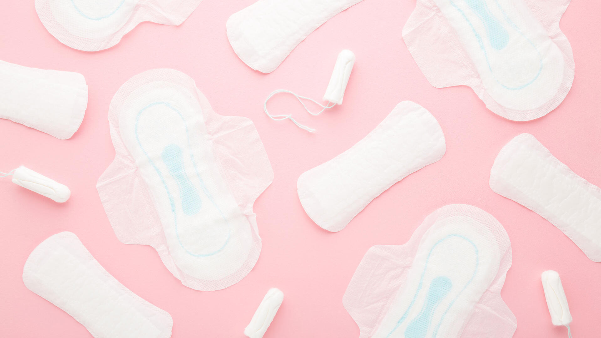 Roze achtergrond met een aantal menstruatieproducten er op uitgestald