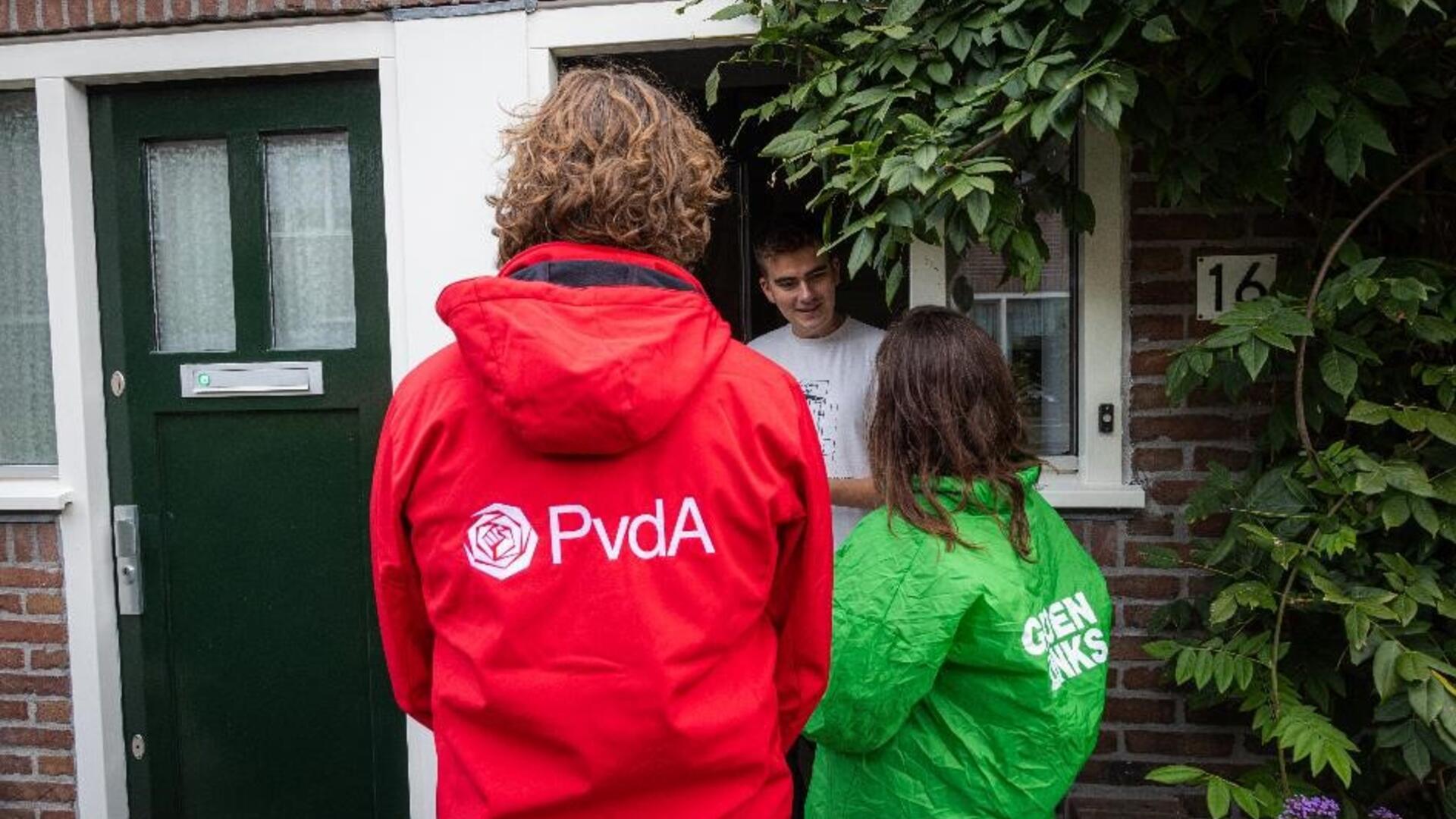 twee personen met een GroenLinks en PvdA jasje bellen aan