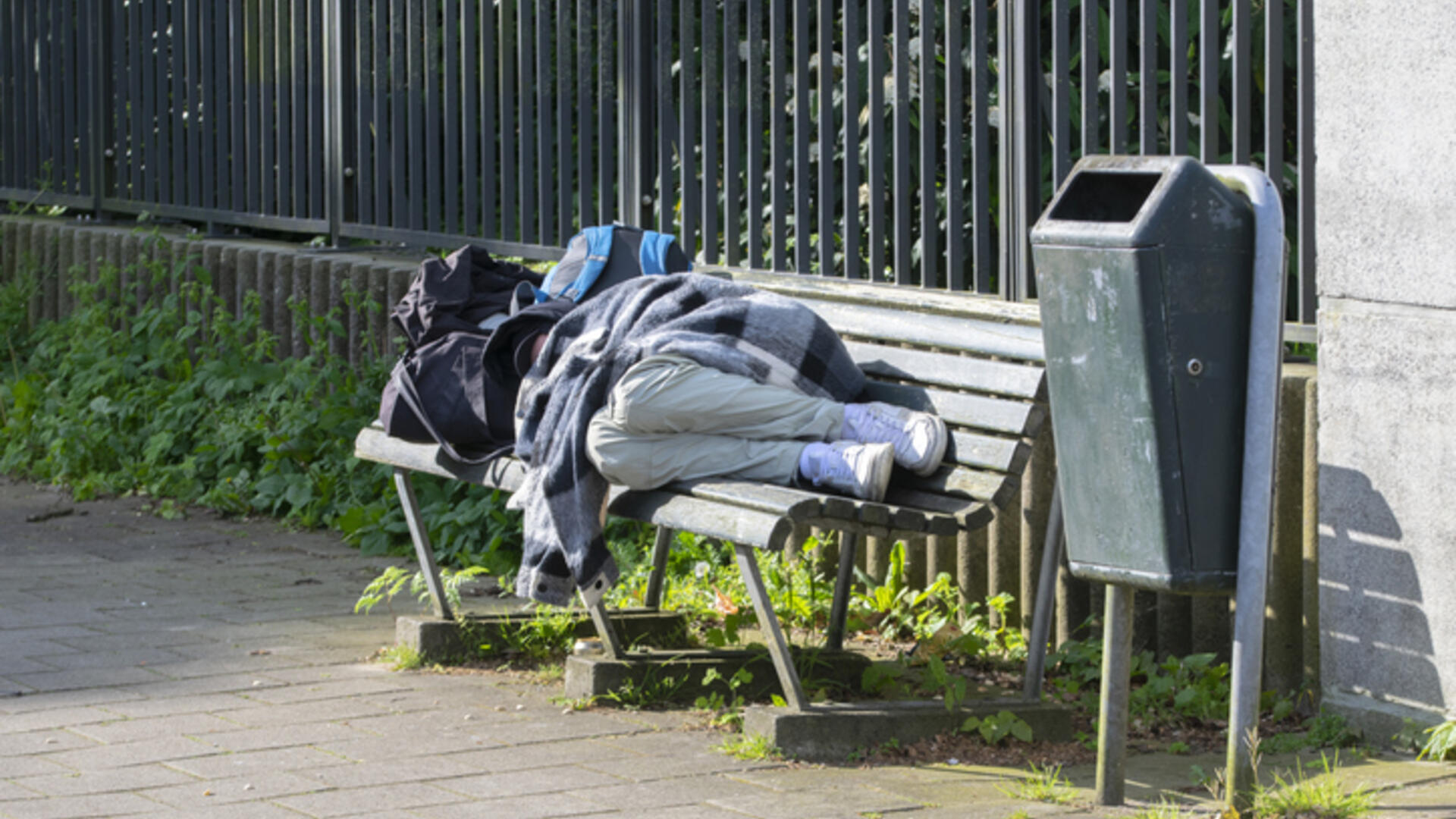 iemand slaapt op een bankje op straat