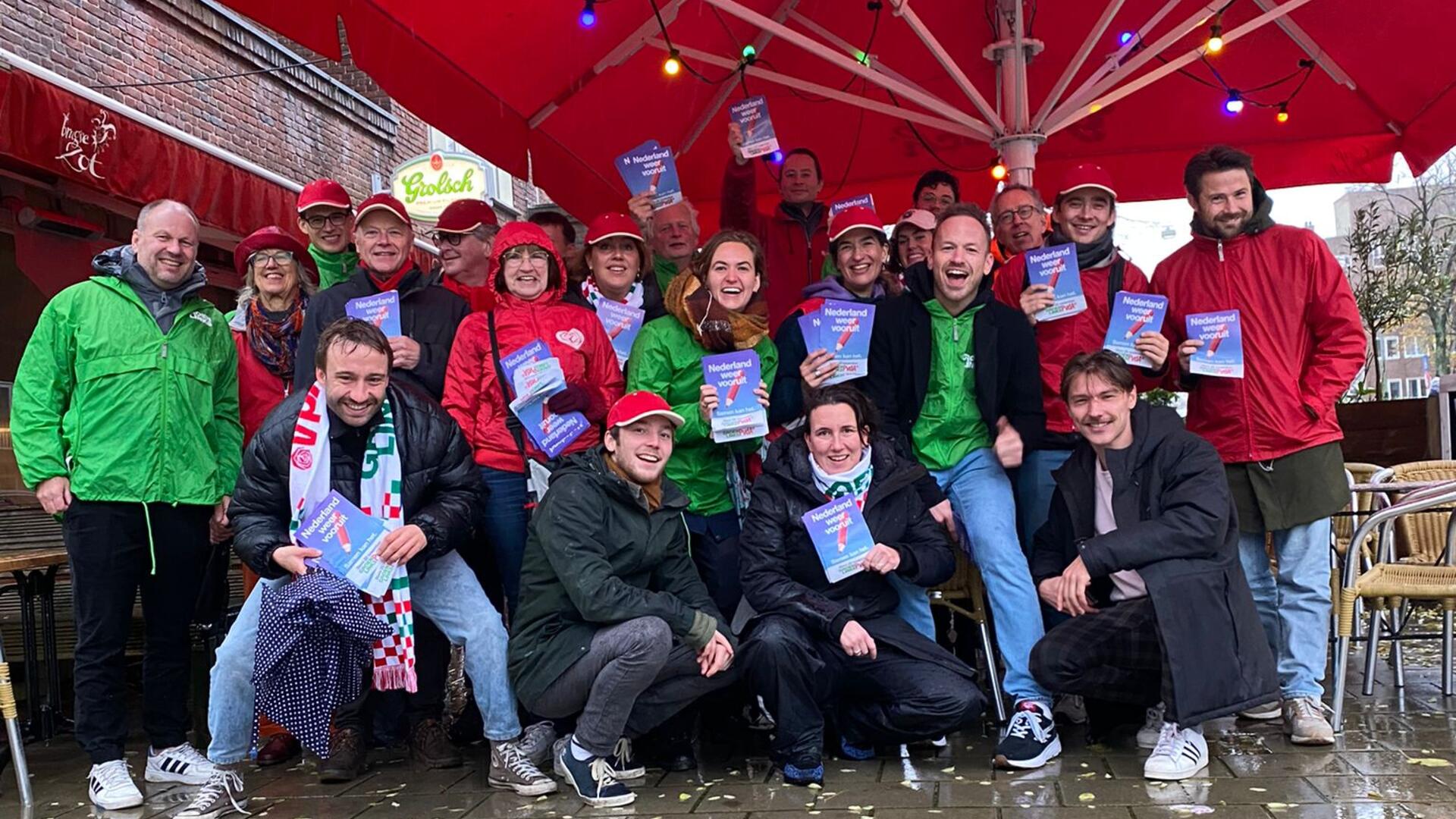 een groep mensen in rode en groene jasjes