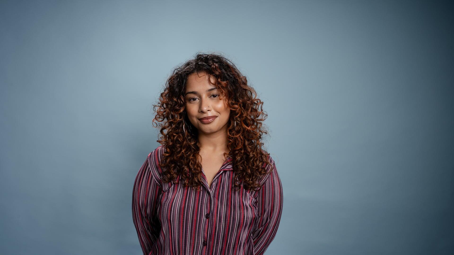 Tanisha kijkt glimlachend de camera in