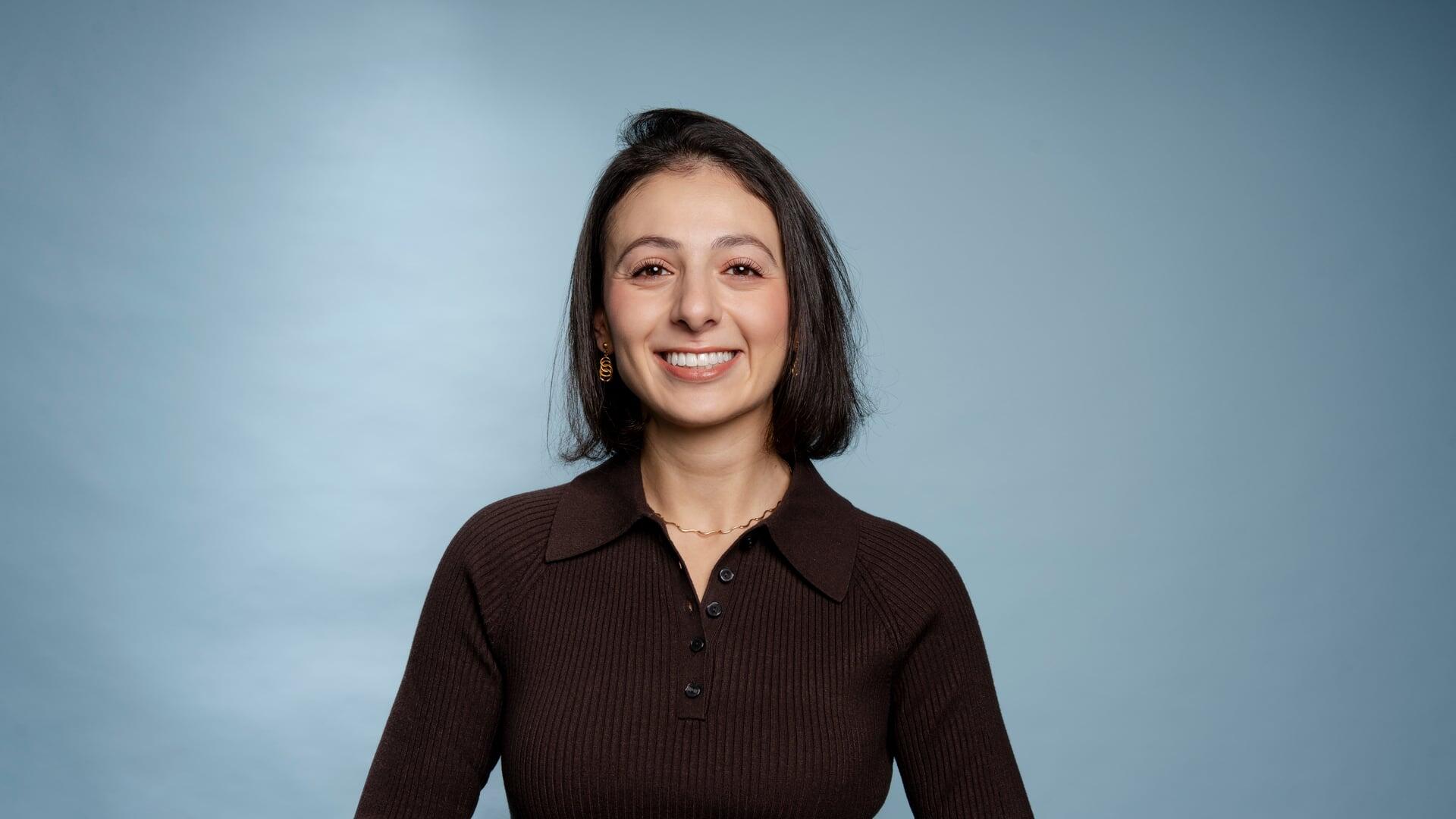 Pelin kijkt lachend in de camera met haar handen op haar rug