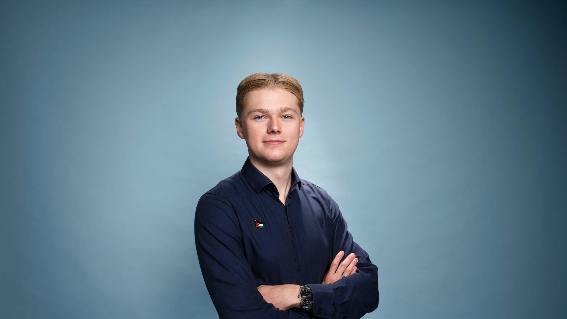 Pelle kijkt met zijn armen over elkaar glimlachend de camera in