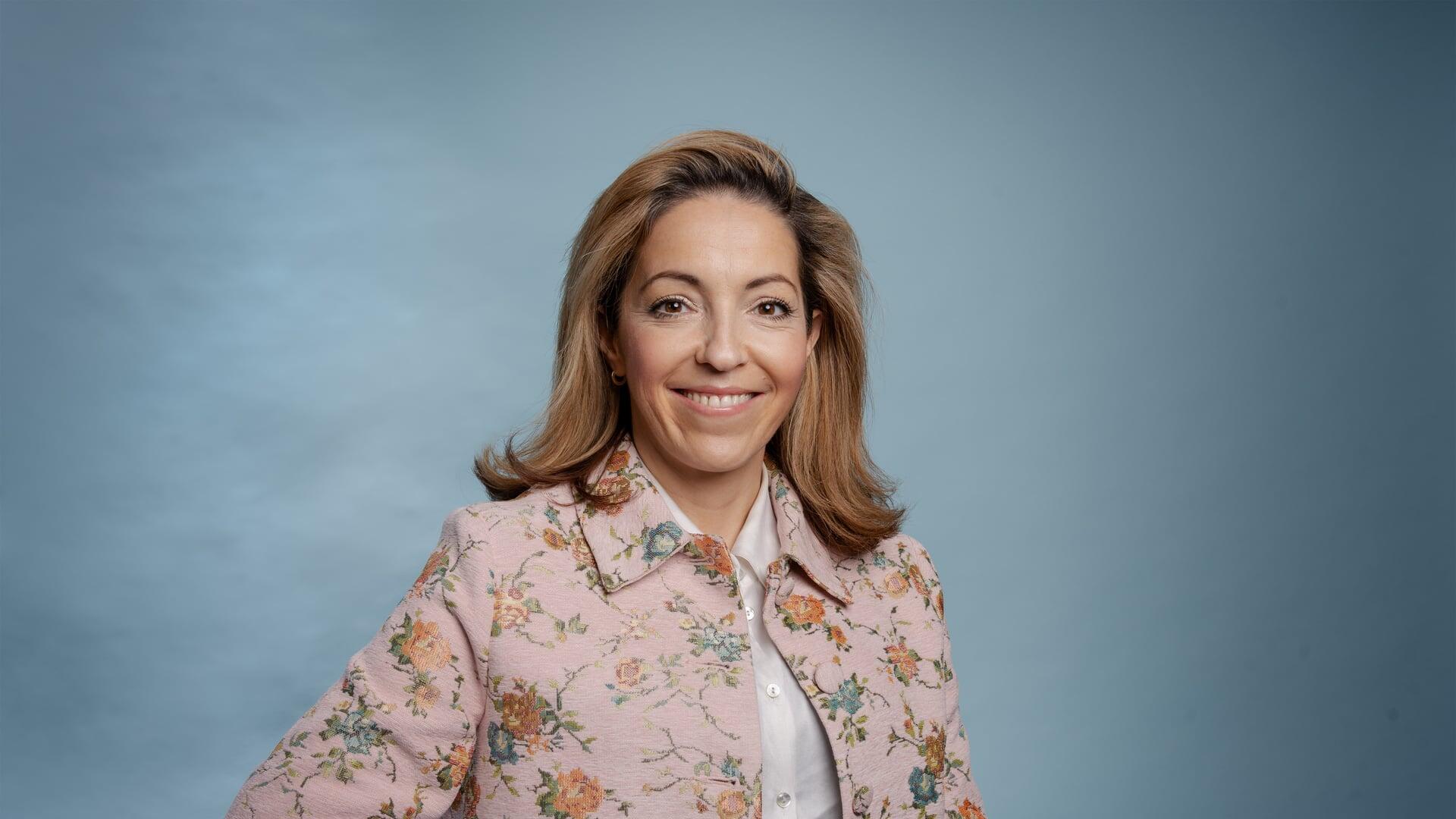 Nora kijkt lachende de camera in