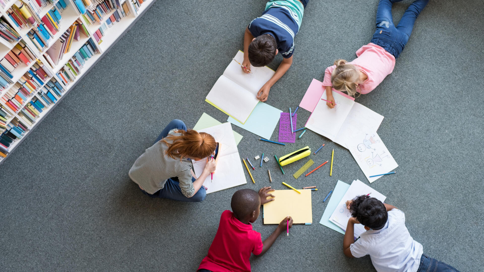 kinderen in een bibliotheek maken samen huiswerk