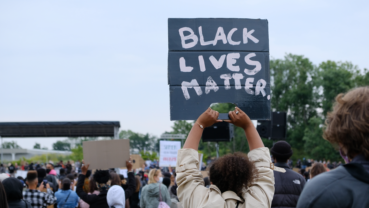 Persoon met een demonstratiebord met de tekst "Black Lives Matter"